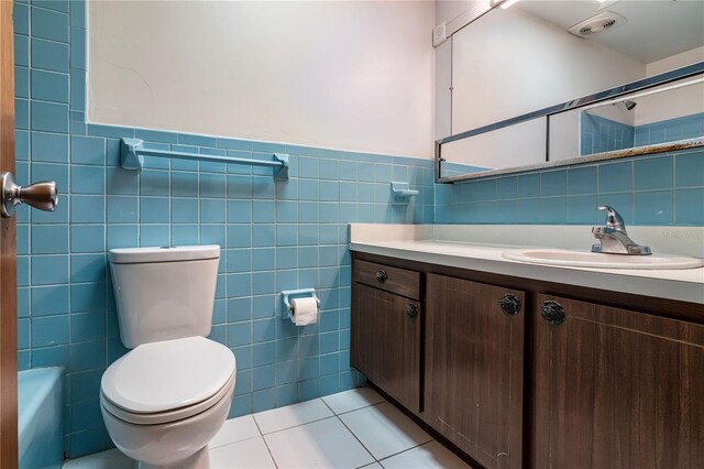 3121 Thistlehill Dr, Winter Park, FL 32792 - bathroom featuring tile walls, vanity, toilet, a shower, and tile patterned flooring
