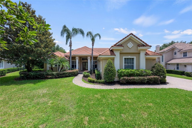 8475 Eagles Loop Cir, Windermere, FL 34786 - mediterranean / spanish-style home featuring a tiled roof, stucco siding, decorative driveway, a front lawn, and an attached garage