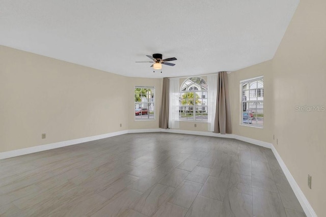 2040 Royal Bay Blvd Unit 31, Kissimmee, FL 34746 - unfurnished room featuring plenty of natural light, a ceiling fan, and baseboards
