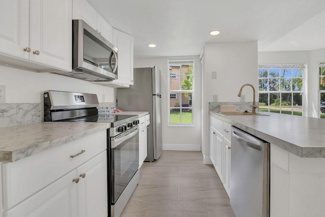 2040 Royal Bay Blvd Unit 31, Kissimmee, FL 34746 - kitchen featuring appliances with stainless steel finishes, a sink, healthy amount of natural light, white cabinets, and recessed lighting