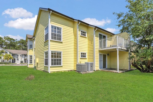 2040 Royal Bay Blvd Unit 31, Kissimmee, FL 34746 - rear view of house with a balcony, a lawn, and central AC unit