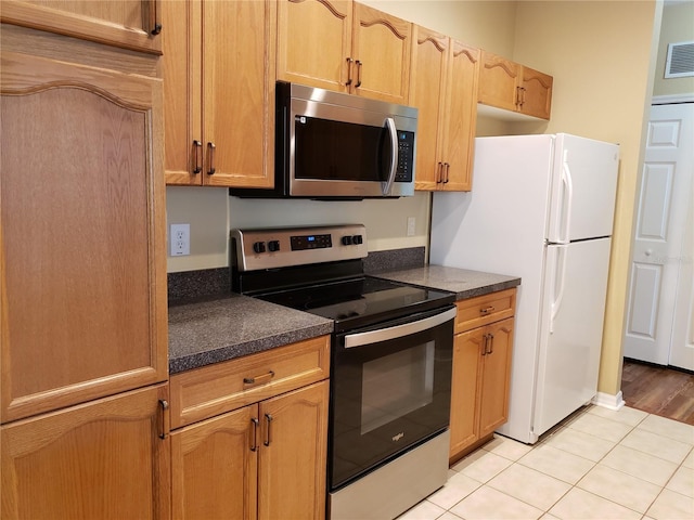 3658 Oakdale Cir Unit 100, Oviedo, FL 32765 - kitchen with appliances with stainless steel finishes, dark countertops, and light tile patterned flooring