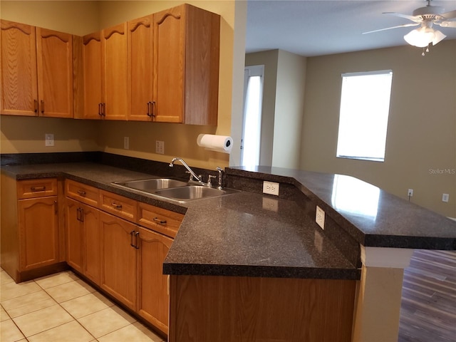 3658 Oakdale Cir Unit 100, Oviedo, FL 32765 - kitchen featuring a sink, a peninsula, ceiling fan, and light tile patterned floors
