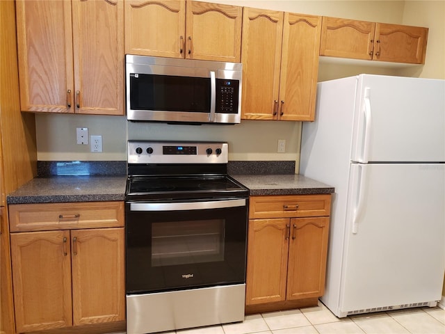 3658 Oakdale Cir Unit 100, Oviedo, FL 32765 - kitchen with appliances with stainless steel finishes, dark countertops, and light tile patterned flooring