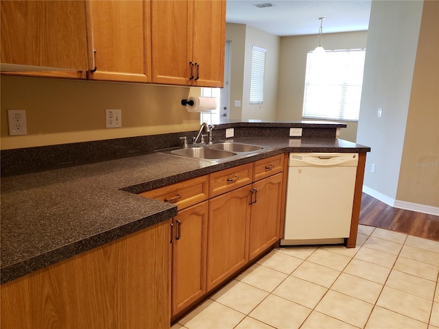3658 Oakdale Cir Unit 100, Oviedo, FL 32765 - kitchen with dishwasher, a sink, a peninsula, hanging light fixtures, and brown cabinetry