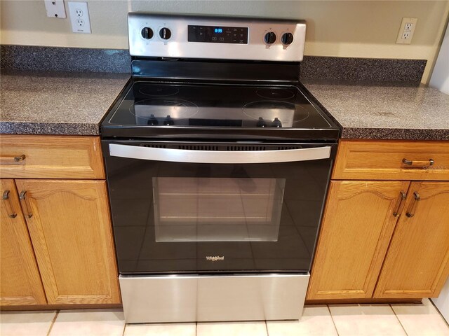 3658 Oakdale Cir Unit 100, Oviedo, FL 32765 - kitchen with electric stove, dark countertops, light tile patterned floors, and brown cabinets