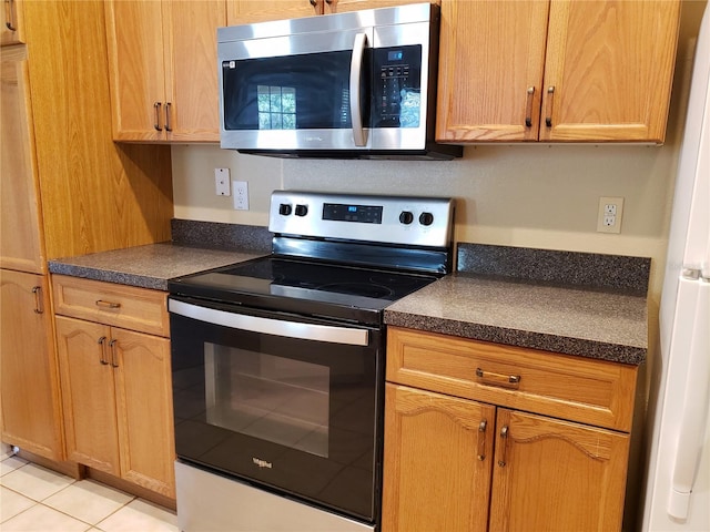 3658 Oakdale Cir Unit 100, Oviedo, FL 32765 - kitchen with appliances with stainless steel finishes, dark countertops, and light tile patterned floors