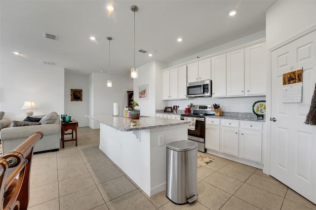 387 Avi Ct, Titusville, FL 32796 - kitchen featuring appliances with stainless steel finishes, open floor plan, light tile patterned floors, white cabinetry, and light stone counters