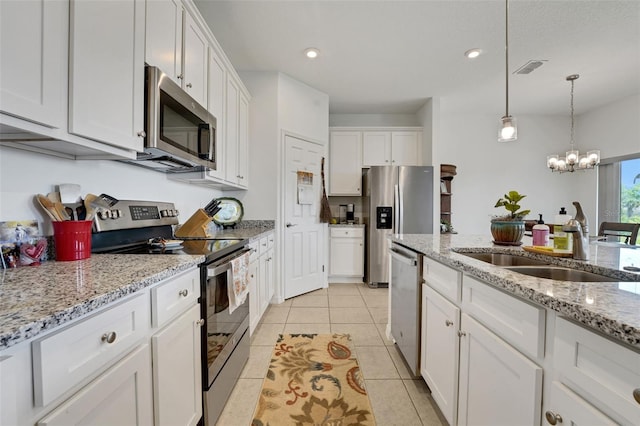 387 Avi Ct, Titusville, FL 32796 - kitchen featuring appliances with stainless steel finishes, white cabinets, a sink, a chandelier, and hanging light fixtures