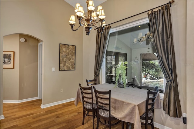 612 Golden Dawn, Apopka, FL 32712 - dining space featuring arched walkways, light wood-style flooring, baseboards, and a chandelier