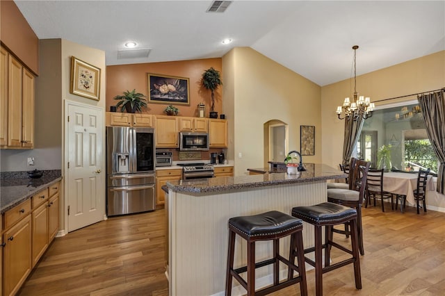 612 Golden Dawn, Apopka, FL 32712 - kitchen with appliances with stainless steel finishes, a chandelier, light wood finished floors, a breakfast bar, and arched walkways