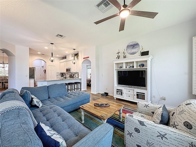 27143 Nostalgia Dr, Leesburg, FL 34748 - living area with arched walkways, ceiling fan, wood finished floors, baseboards, and recessed lighting
