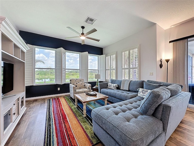 27143 Nostalgia Dr, Leesburg, FL 34748 - living room with ceiling fan, wood finished floors, and healthy amount of natural light