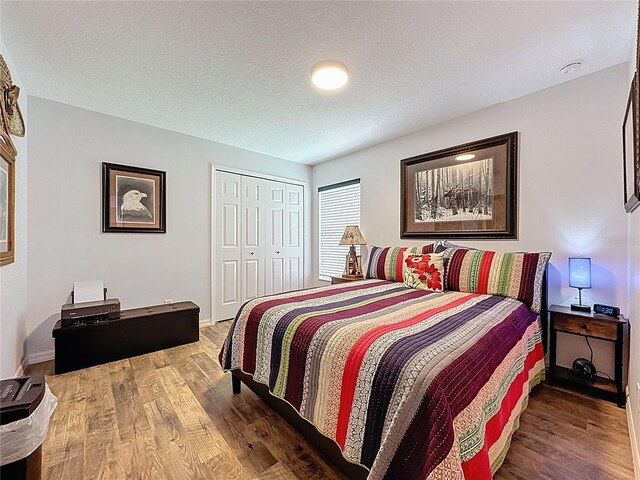 27143 Nostalgia Dr, Leesburg, FL 34748 - bedroom featuring wood finished floors, a closet, baseboards, and a textured ceiling
