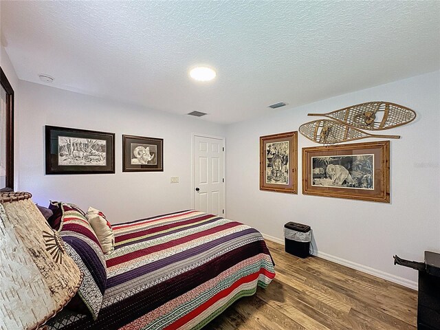 27143 Nostalgia Dr, Leesburg, FL 34748 - bedroom featuring wood finished floors, baseboards, and a textured ceiling