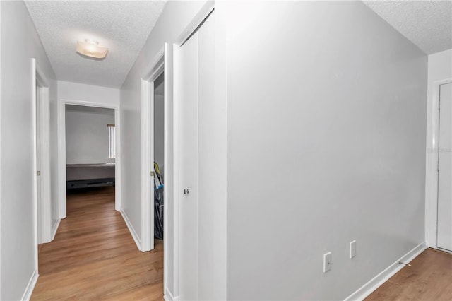 8443 SW 109th Pl, Ocala, FL 34481 - corridor featuring a textured ceiling, light wood-style flooring, and baseboards