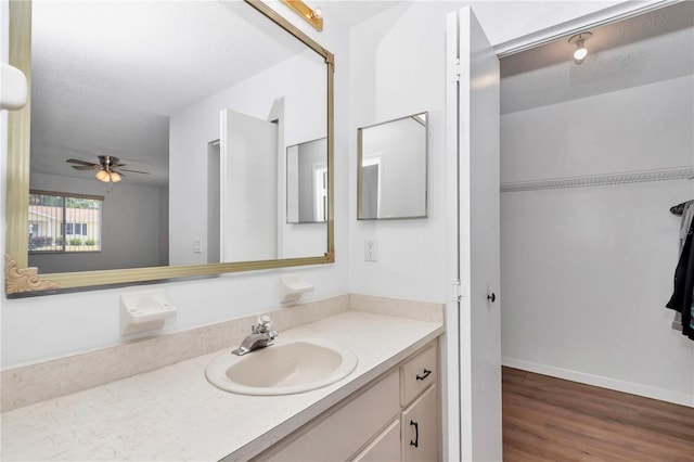 8443 SW 109th Pl, Ocala, FL 34481 - bathroom with vanity, wood finished floors, a textured ceiling, ceiling fan, and a walk in closet