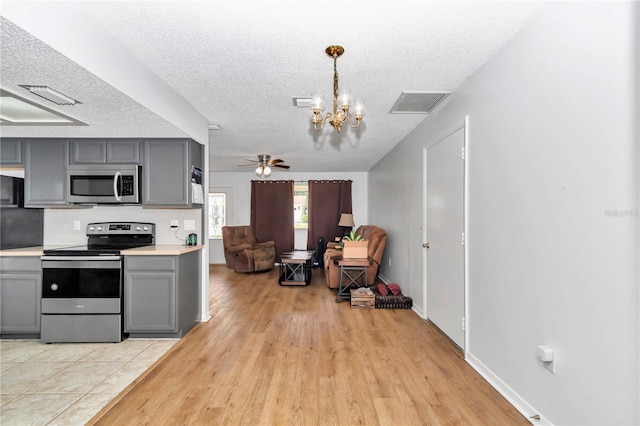 8443 SW 109th Pl, Ocala, FL 34481 - kitchen with appliances with stainless steel finishes, gray cabinets, a chandelier, light wood-style flooring, and light countertops
