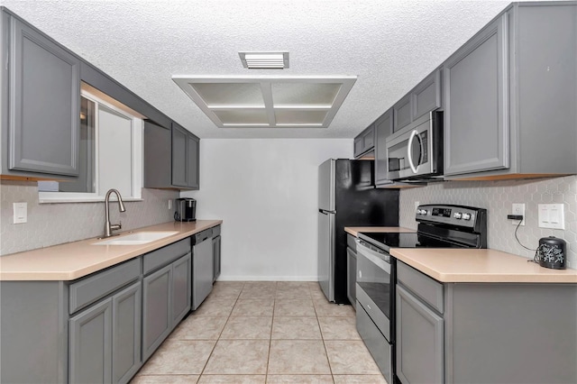 8443 SW 109th Pl, Ocala, FL 34481 - kitchen featuring stainless steel appliances, a sink, gray cabinets, a textured ceiling, and light countertops