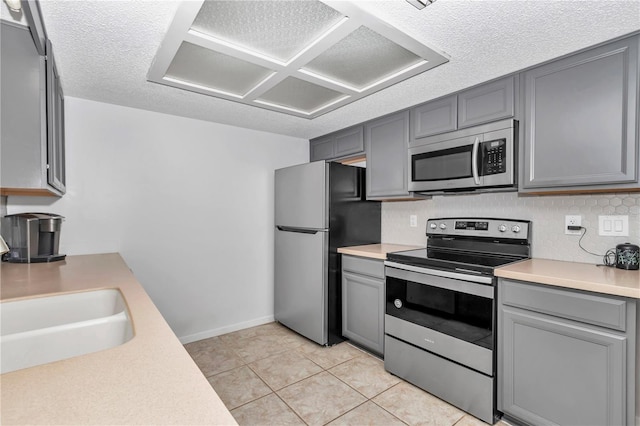 8443 SW 109th Pl, Ocala, FL 34481 - kitchen featuring stainless steel appliances, gray cabinetry, light countertops, a textured ceiling, and a sink