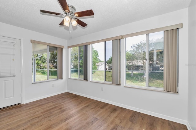 8443 SW 109th Pl, Ocala, FL 34481 - empty room featuring plenty of natural light, ceiling fan, wood finished floors, baseboards, and a textured ceiling