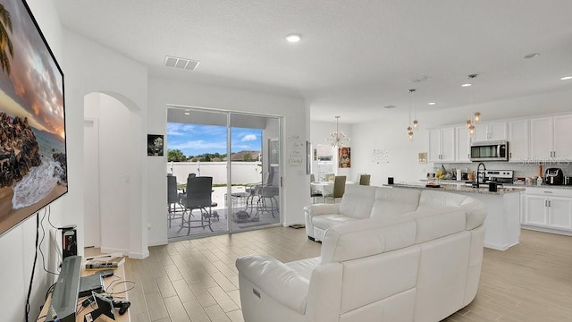 6013 Mount Zion Cir, Deland, FL 32724 - living area with light wood finished floors, arched walkways, and recessed lighting