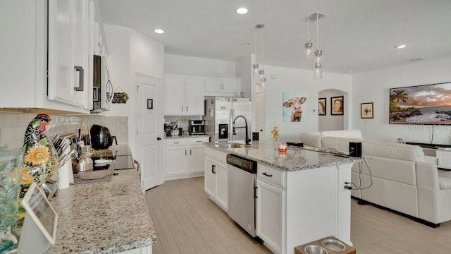 6013 Mount Zion Cir, Deland, FL 32724 - kitchen with stainless steel appliances, open floor plan, arched walkways, a sink, and tasteful backsplash