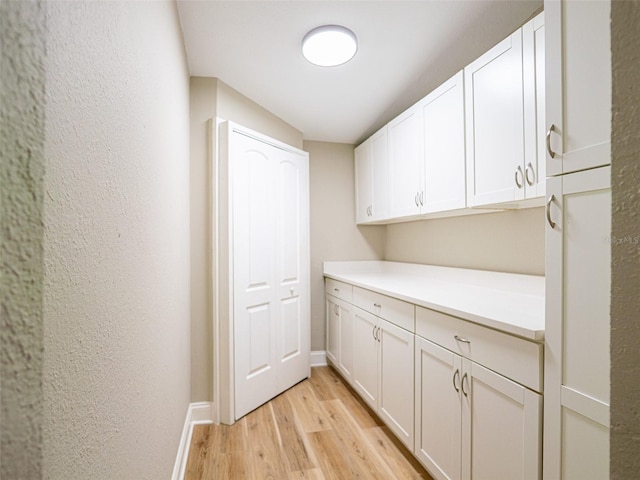 1229 Deneece Ter, Daytona Beach, FL 32117 - laundry room with light wood-style floors, baseboards, and a textured wall