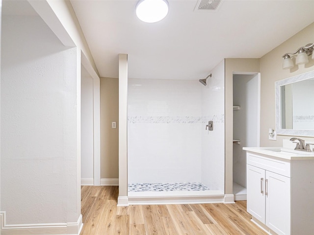 1229 Deneece Ter, Daytona Beach, FL 32117 - full bathroom featuring a tile shower, vanity, wood finished floors, and baseboards