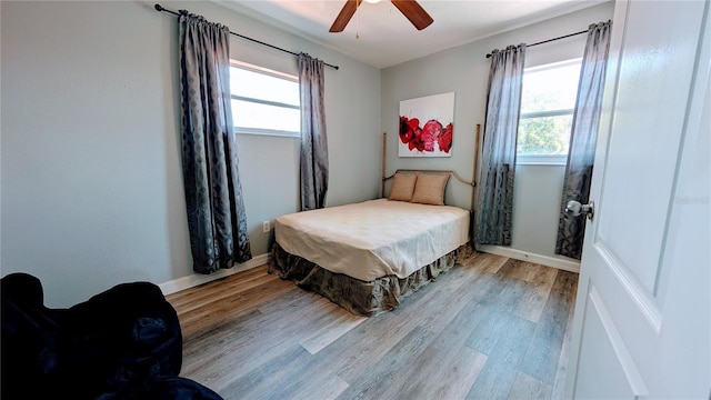 331 Greens End St, Orlando, FL 32810 - bedroom featuring multiple windows, light wood-style floors, and baseboards
