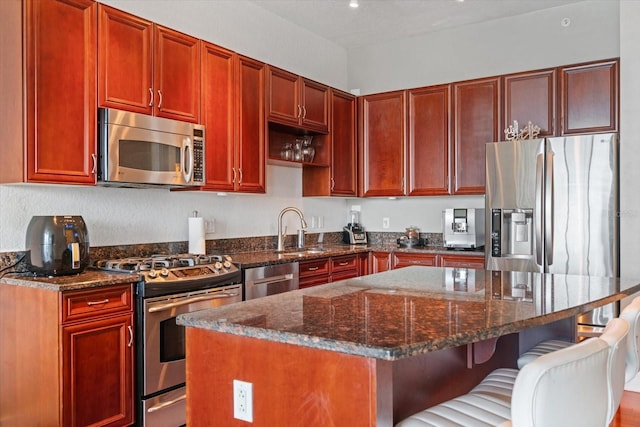 150 E Robinson St Unit 16B-2 # 1605, Orlando, FL 32801 - kitchen with appliances with stainless steel finishes, a sink, dark brown cabinets, and a kitchen island