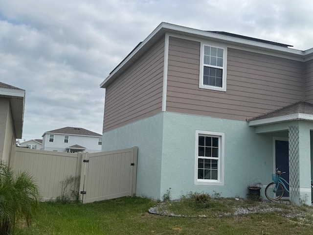 268 Fiddlewood Ct, Davenport, FL 33837 - view of home's exterior with a gate and stucco siding