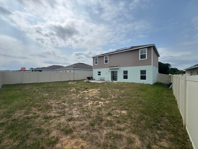 268 Fiddlewood Ct, Davenport, FL 33837 - back of property featuring roof mounted solar panels and stucco siding