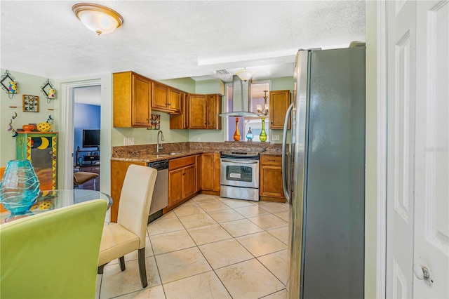 1919 E S St, Orlando, FL 32801 - kitchen featuring range hood, stainless steel appliances, brown cabinetry, dark stone countertops, and a textured ceiling