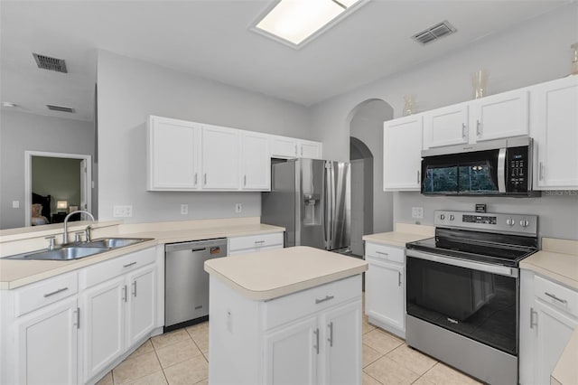1245 Reagans Reserve Blvd, Apopka, FL 32712 - kitchen with stainless steel appliances, a sink, arched walkways, light countertops, and white cabinetry