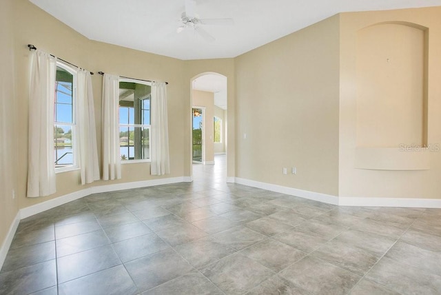 529 Quail Down Dr, Debary, FL 32713 - tiled empty room with arched walkways, healthy amount of natural light, and baseboards