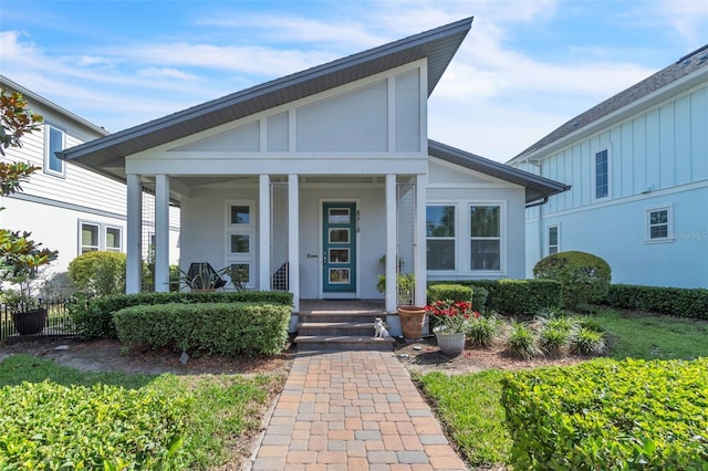 8518 Nemours Pkwy, Orlando, FL 32827 - view of front of home with a porch, board and batten siding, and stucco siding