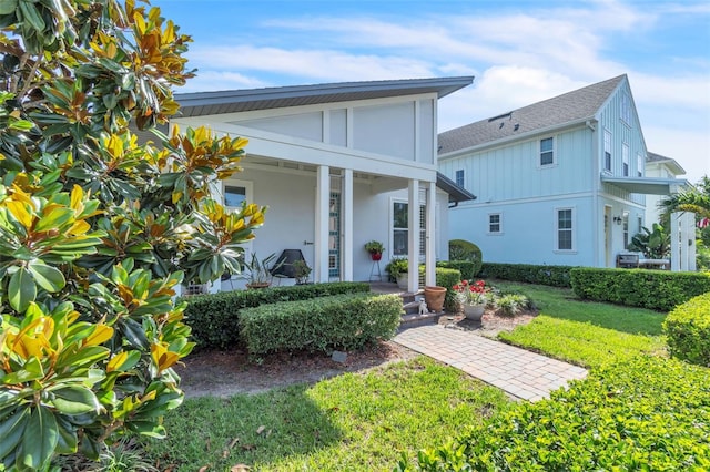 8518 Nemours Pkwy, Orlando, FL 32827 - view of front of property featuring a front yard, a porch, stucco siding, and a shingled roof