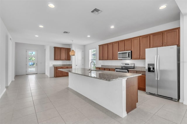 8518 Nemours Pkwy, Orlando, FL 32827 - kitchen featuring appliances with stainless steel finishes, a sink, brown cabinetry, light stone counters, and recessed lighting