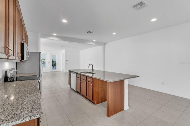 8518 Nemours Pkwy, Orlando, FL 32827 - kitchen with a sink, appliances with stainless steel finishes, brown cabinetry, a center island with sink, and recessed lighting