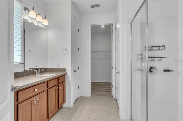 8518 Nemours Pkwy, Orlando, FL 32827 - full bath featuring a shower stall, vanity, a spacious closet, and tile patterned flooring