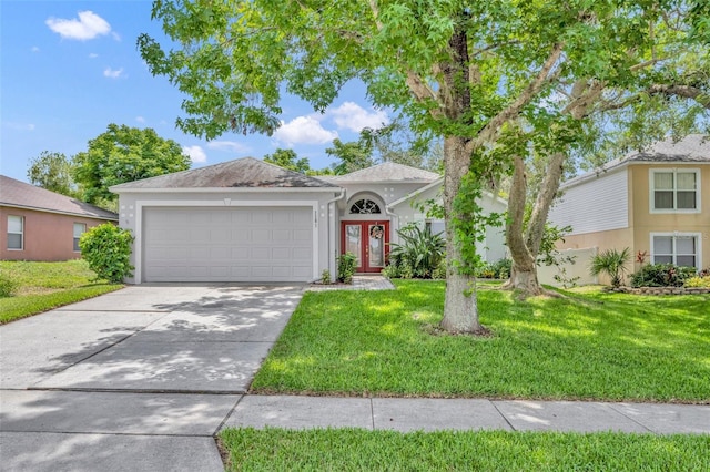1181 Welch Hill Cir, Apopka, FL 32712 - view of front of home featuring a garage, a front lawn, concrete driveway, stucco siding, and french doors