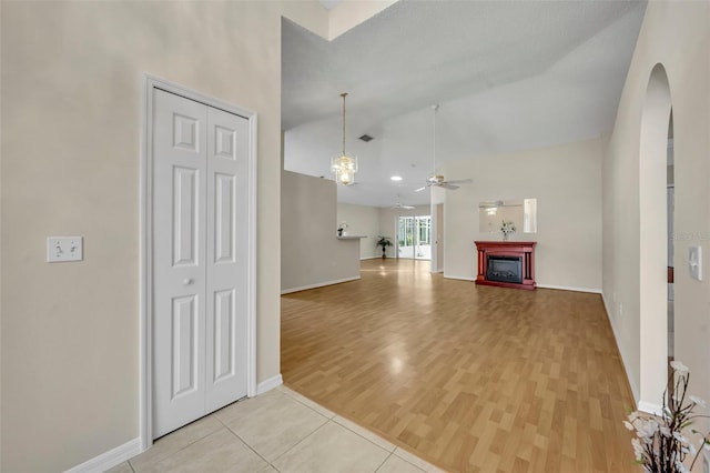 1181 Welch Hill Cir, Apopka, FL 32712 - unfurnished living room with light wood-type flooring, arched walkways, ceiling fan, a fireplace, and high vaulted ceiling