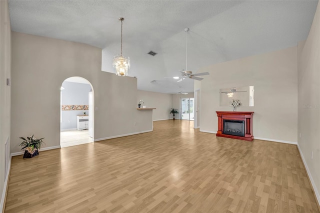 1181 Welch Hill Cir, Apopka, FL 32712 - unfurnished living room with ceiling fan, arched walkways, high vaulted ceiling, light wood-type flooring, and a fireplace