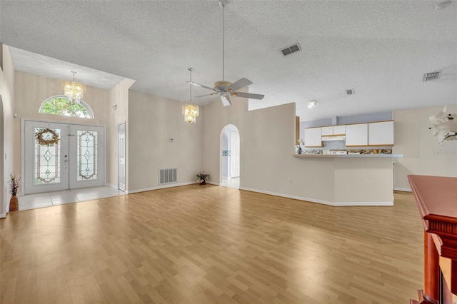 1181 Welch Hill Cir, Apopka, FL 32712 - unfurnished living room with arched walkways, a chandelier, a textured ceiling, a ceiling fan, and light wood finished floors