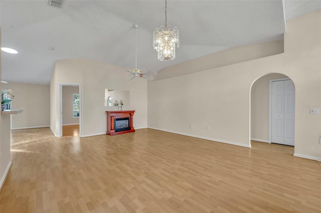 1181 Welch Hill Cir, Apopka, FL 32712 - unfurnished living room with vaulted ceiling, arched walkways, light wood-type flooring, ceiling fan, and a glass covered fireplace