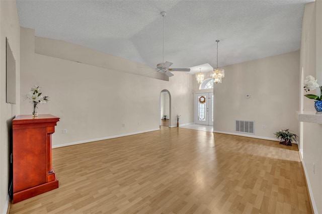 1181 Welch Hill Cir, Apopka, FL 32712 - unfurnished living room featuring light wood finished floors, arched walkways, ceiling fan, baseboards, and a textured ceiling