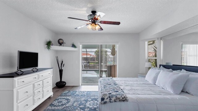 260 Coronado Dr, Punta Gorda, FL 33950 - bedroom featuring access to outside, a textured ceiling, multiple windows, dark wood-type flooring, and a ceiling fan