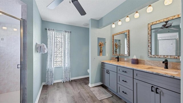 260 Coronado Dr, Punta Gorda, FL 33950 - bathroom featuring ceiling fan, double vanity, a shower stall, wood finished floors, and toilet