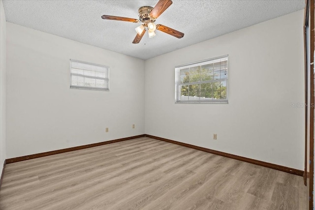 3942 Orange Lake Dr, Orlando, FL 32817 - empty room featuring healthy amount of natural light, light wood-style floors, a textured ceiling, a ceiling fan, and baseboards
